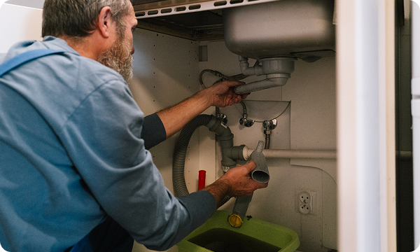 A plumber working under a sink